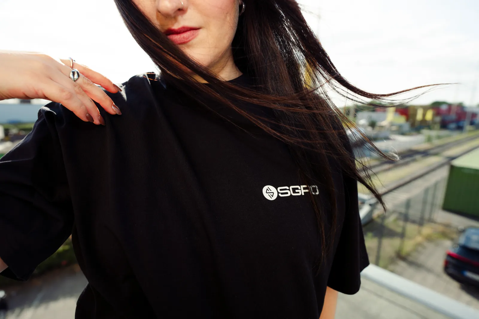 Nahaufnahme: weißes SGRO Brustlogo auf dem schwarzen Oversized Tee