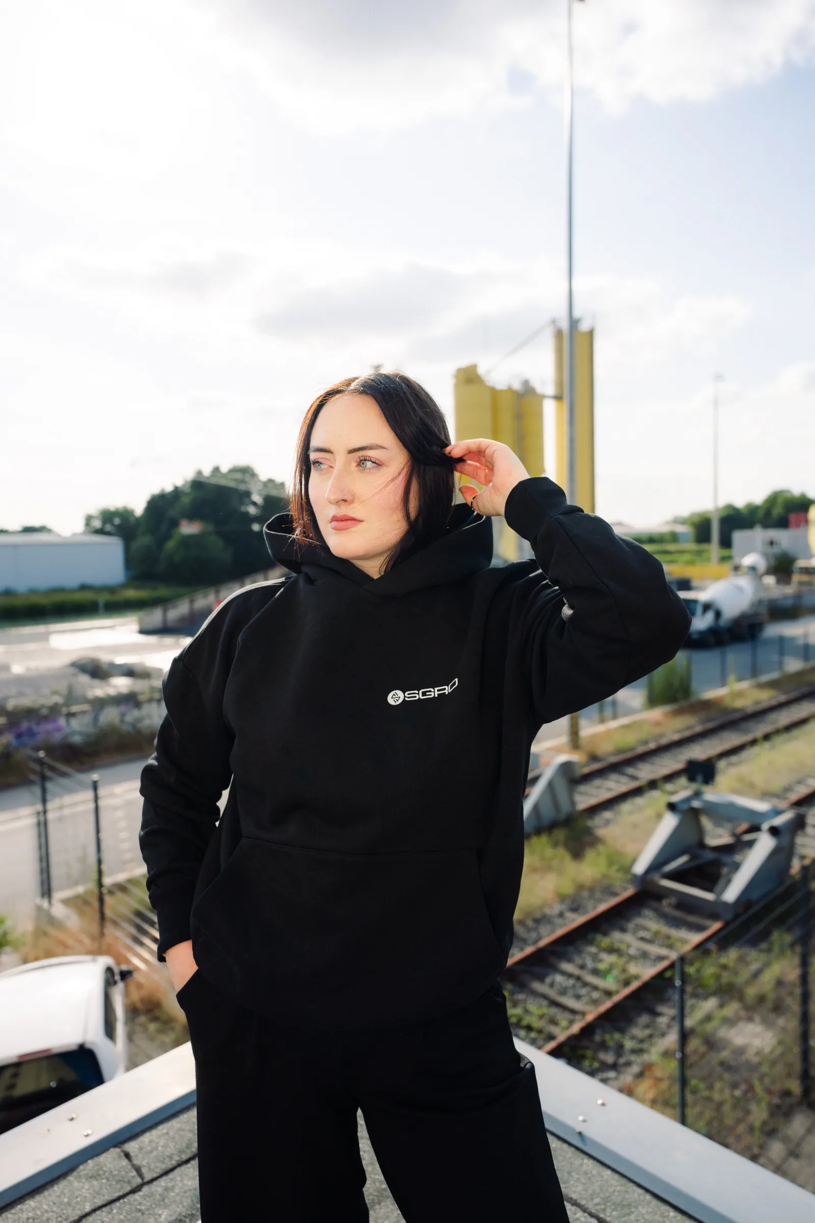 Leonie im Heavy Hoodie vor den Gleisen